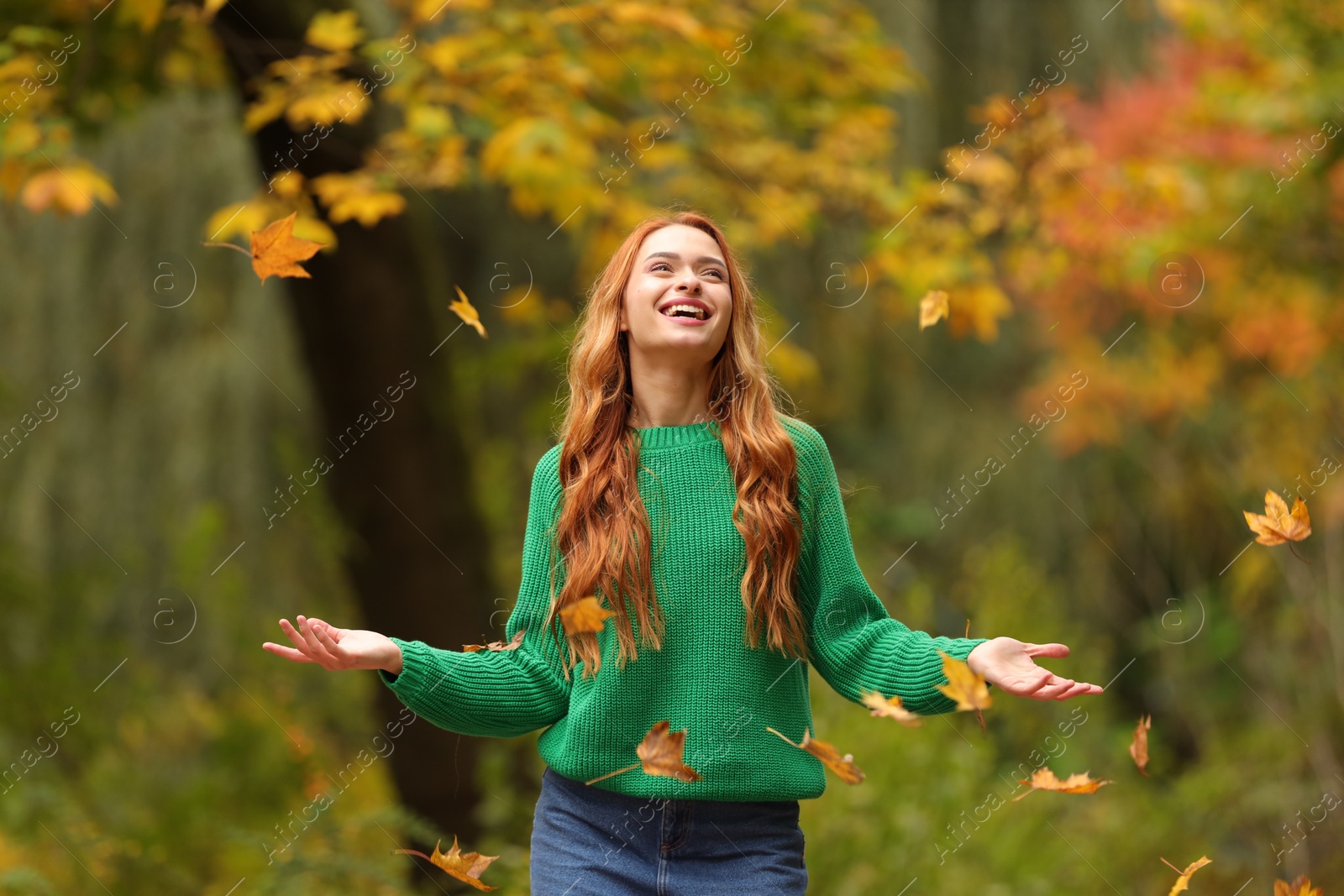 Photo of Autumn vibes. Happy woman throwing leaves up in park