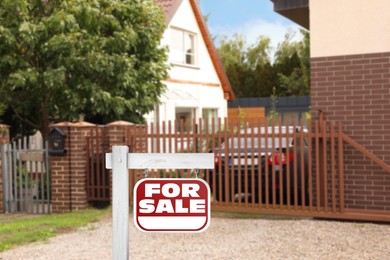 Image of Red sign with words For Sale near beautiful house outdoors
