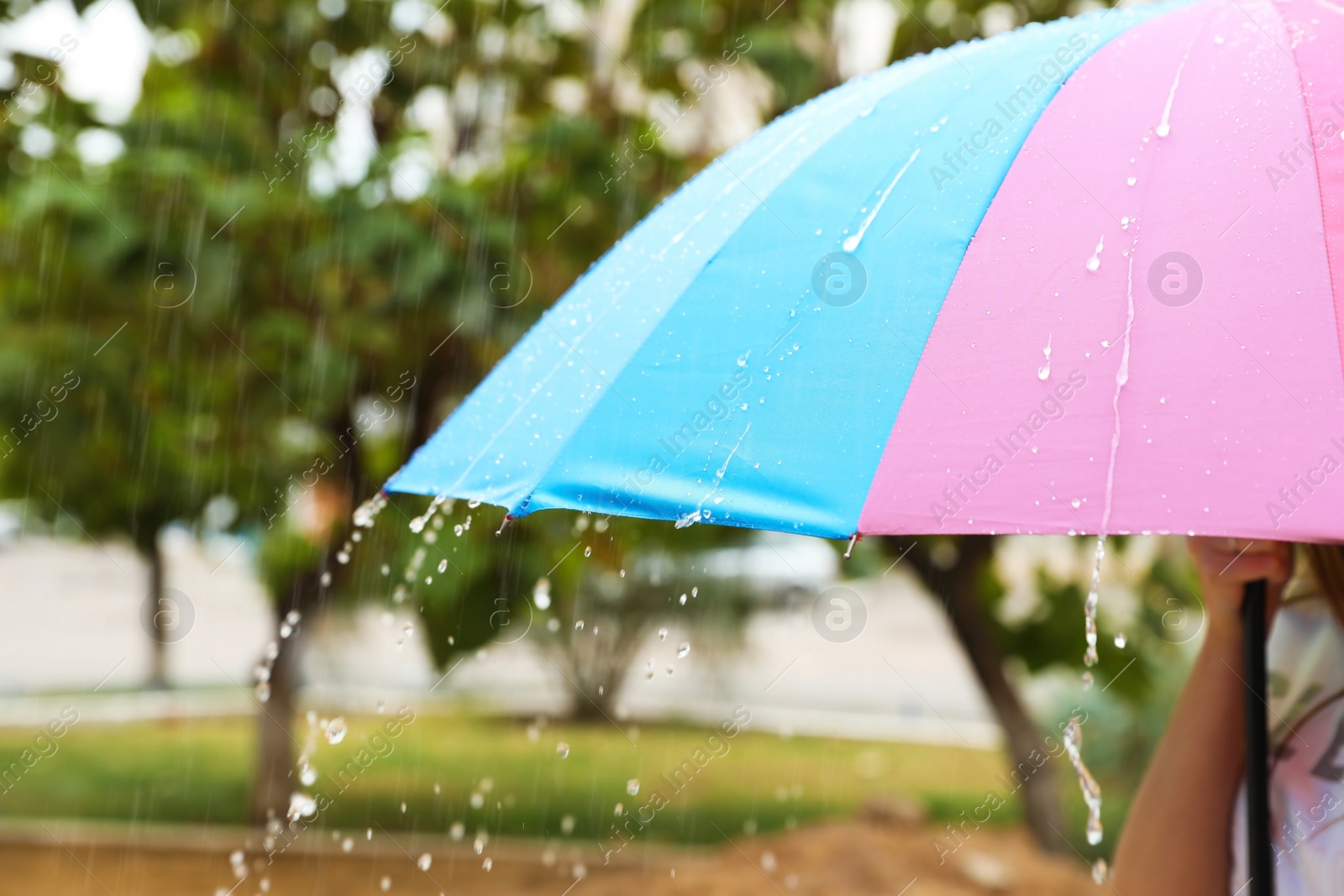 Photo of Person with bright umbrella under rain on street, closeup