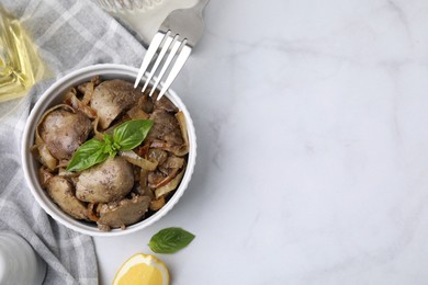 Delicious fried chicken liver with onion and basil served on white marble table, flat lay. Space for text