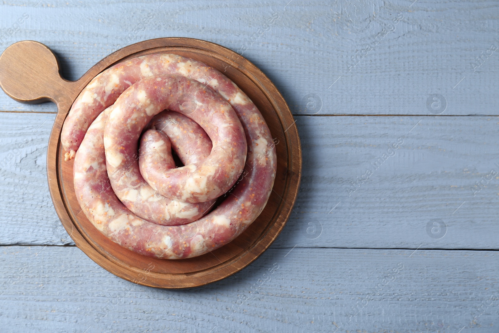 Photo of Homemade sausages on light grey wooden table, top view. Space for text