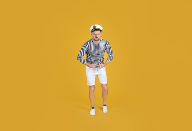 Photo of Serious sailor showing strength on yellow background
