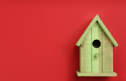 Beautiful bird house on red background, top view. Space for text