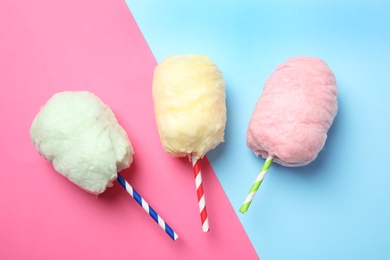 Photo of Straws with yummy cotton candy on color background, top view