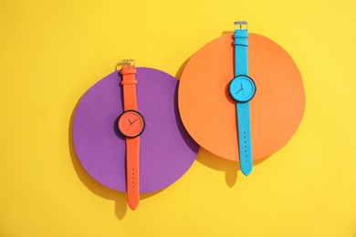 Photo of Composition with stylish wrist watches on color background, flat lay. Fashion accessory