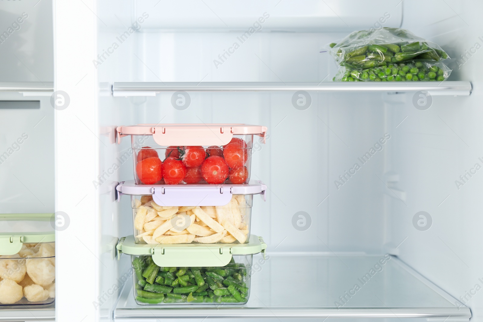 Photo of Plastic bags and containers with different frozen vegetables in refrigerator