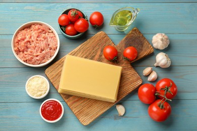 Ingredients for lasagna on blue wooden table, flat lay