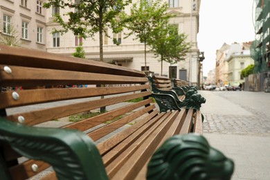 Photo of View of wooden bench with wrought legs on city street