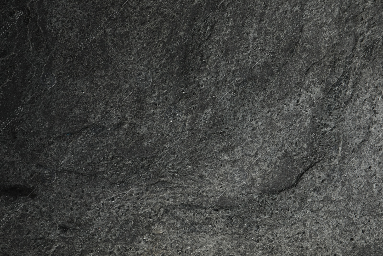 Photo of Texture of dark grey stone surface as background, closeup