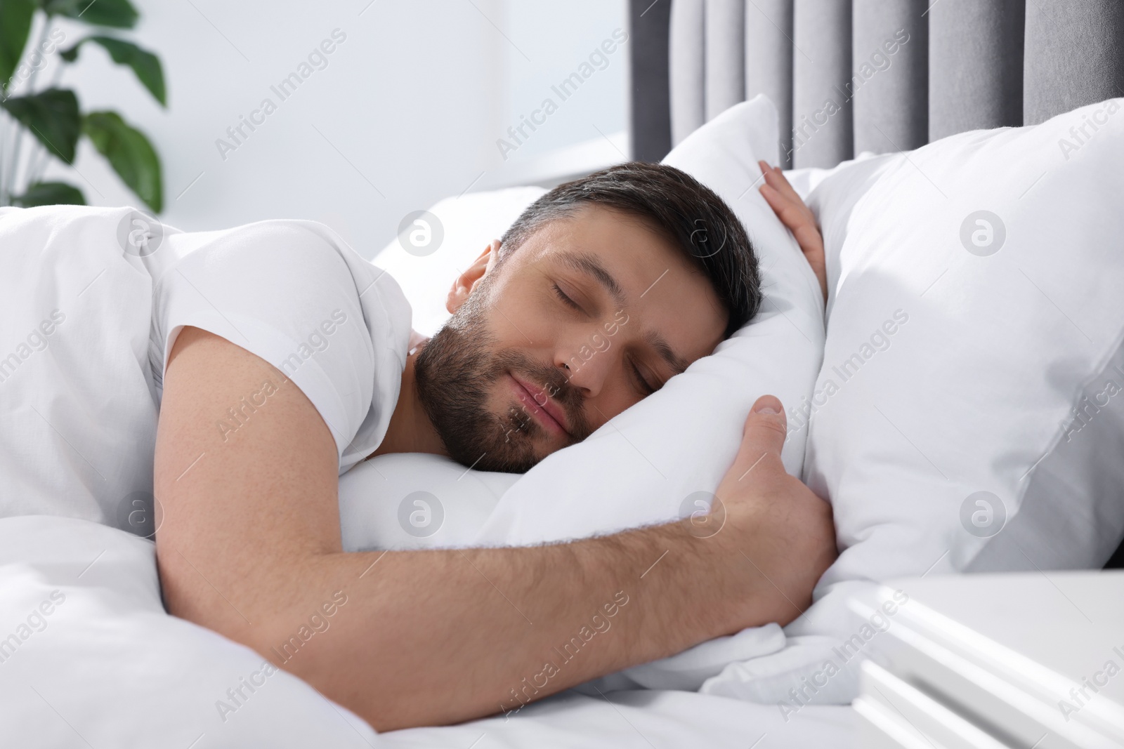 Photo of Handsome man sleeping in soft bed at home