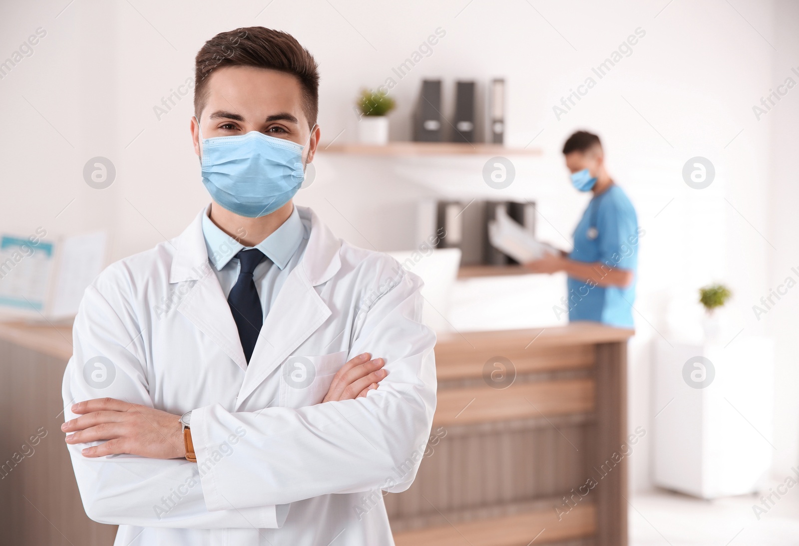 Image of Young doctor wearing medical mask in modern clinic