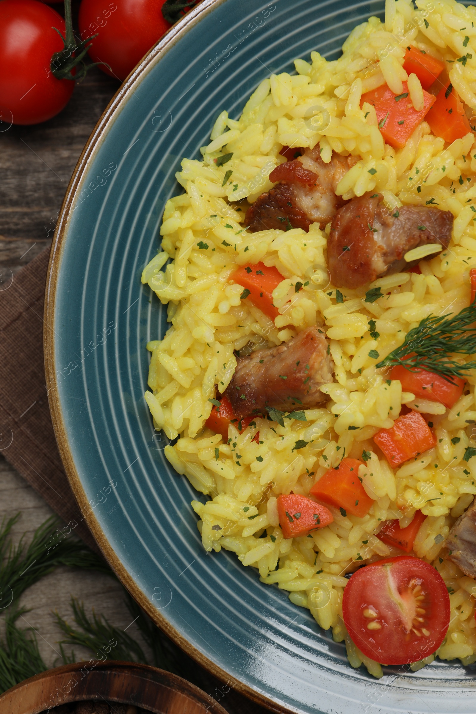 Photo of Delicious pilaf with meat and ingredients on table, flat lay