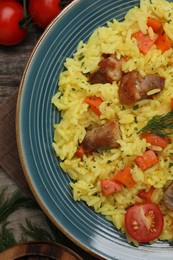 Photo of Delicious pilaf with meat and ingredients on table, flat lay