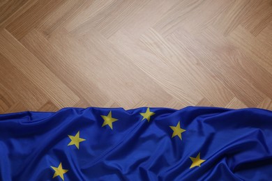 Flag of European Union on wooden table, top view. Space for text