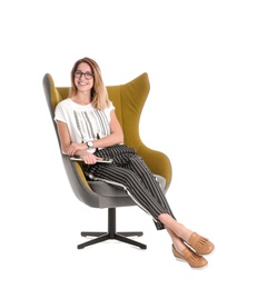 Young woman with tablet sitting in armchair on white background