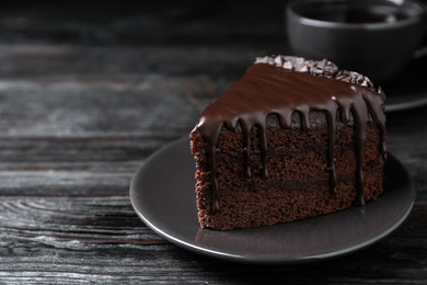 Photo of Delicious chocolate cake on black wooden table, closeup