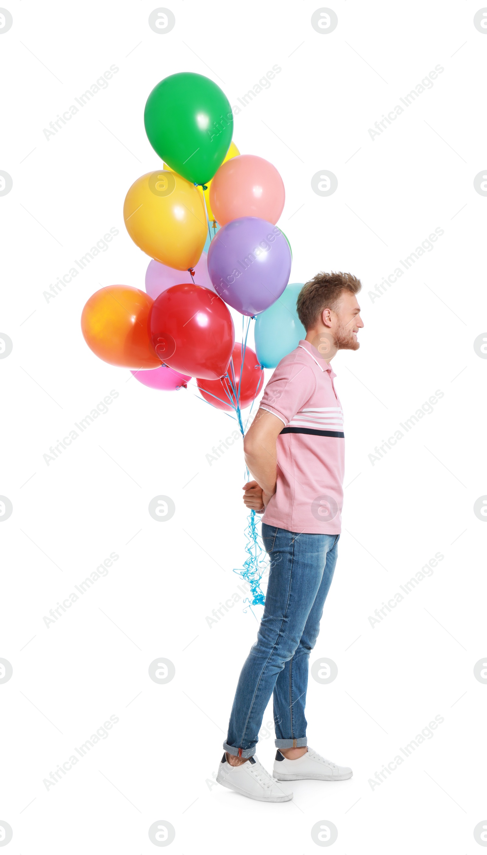 Photo of Young man holding bunch of colorful balloons on white background