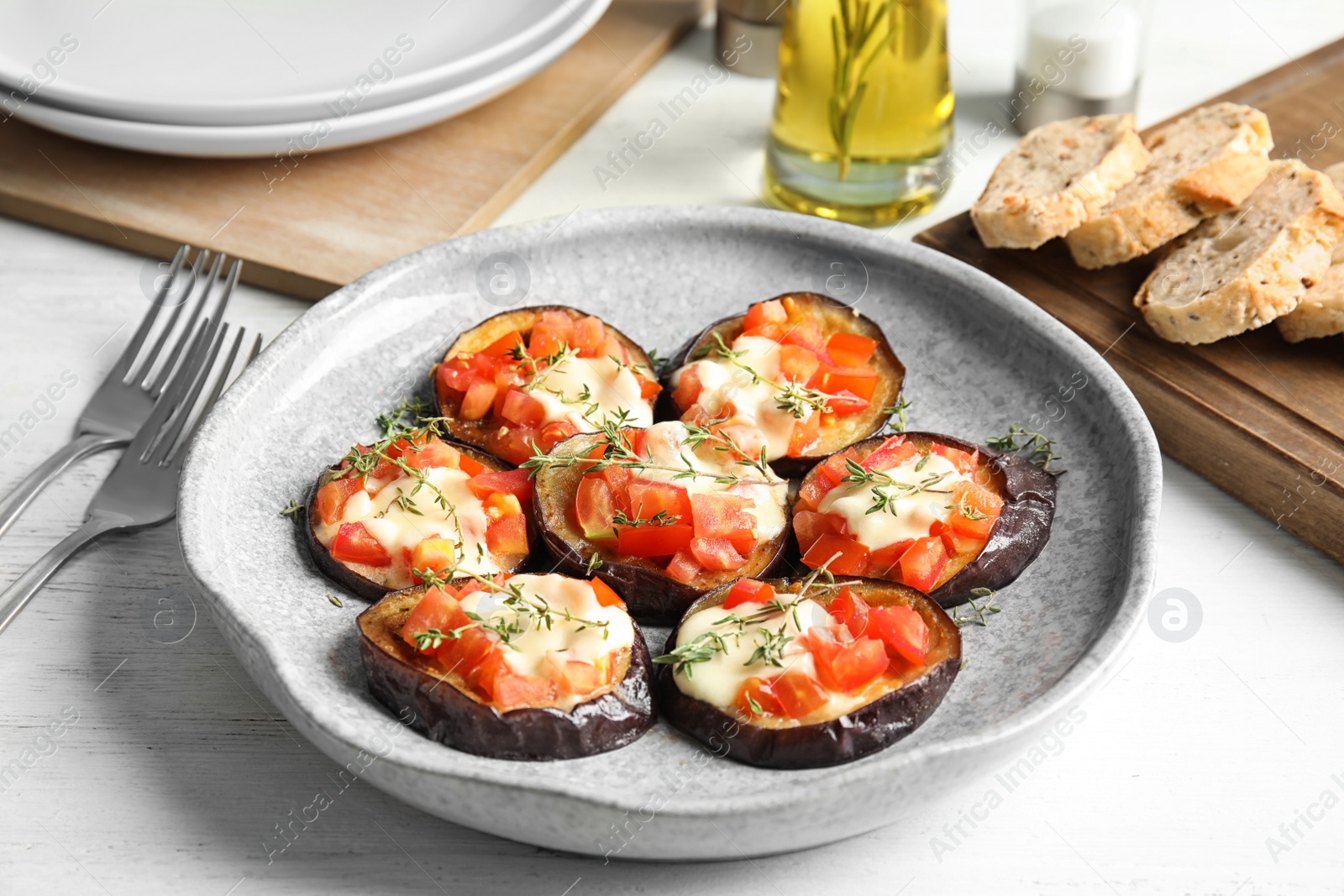 Photo of Baked eggplant with tomatoes, cheese and thyme on table