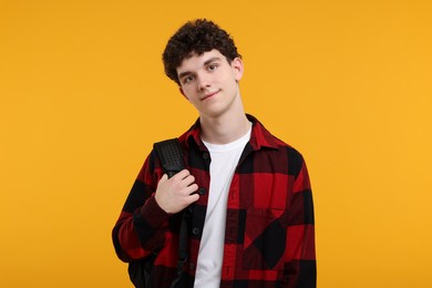 Photo of Portrait of student with backpack on orange background