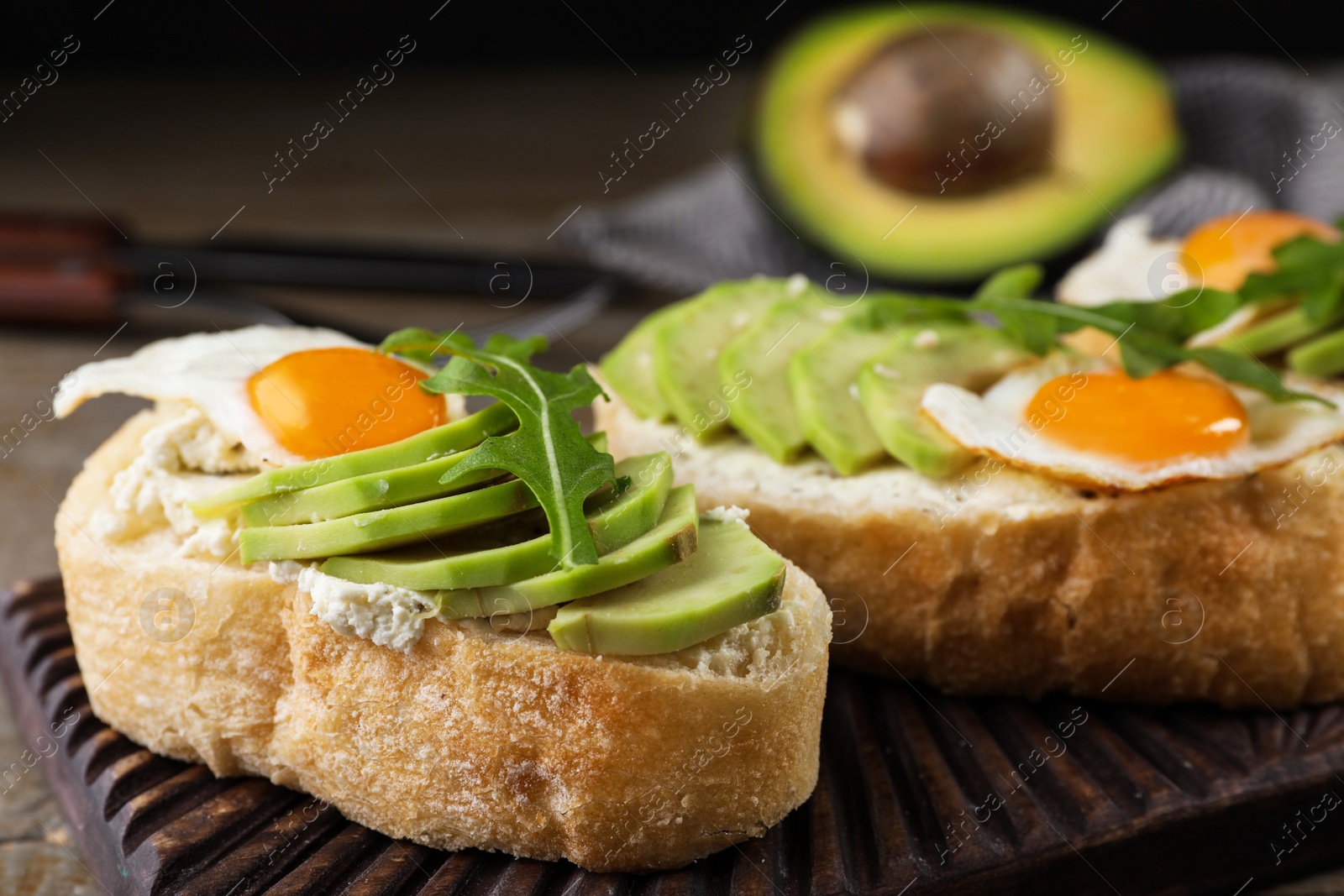 Photo of Delicious avocado sandwiches on wooden board, closeup