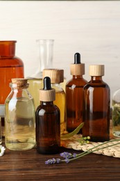 Aromatherapy. Different essential oils and flowers on wooden table