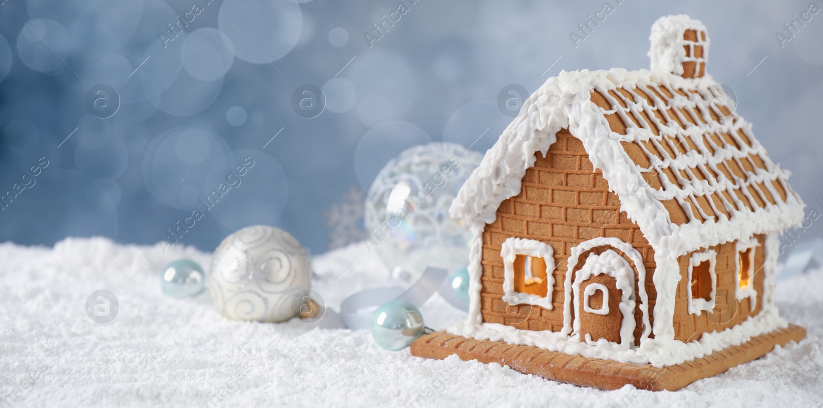 Image of Beautiful gingerbread house decorated with icing on snow, space for text. Banner design