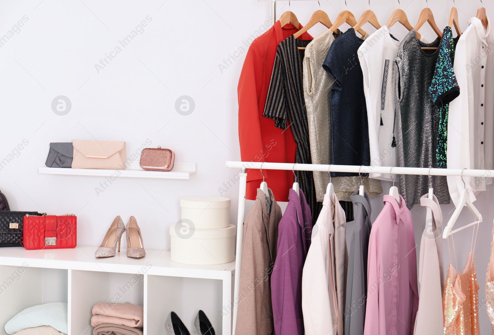 Photo of Racks with clothes in stylish dressing room interior