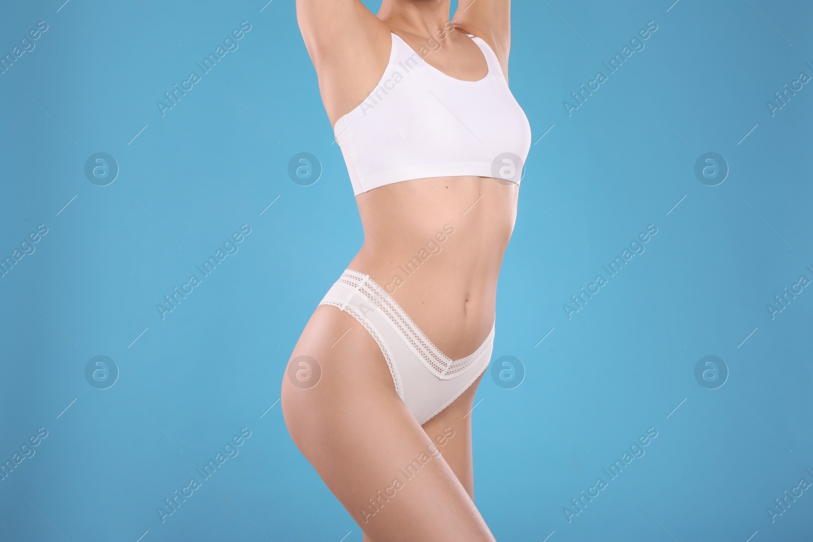 Photo of Closeup view of slim woman in underwear on light blue background. Cellulite problem concept