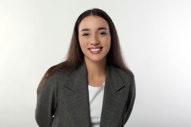 Portrait of happy young woman in stylish jacket on white background