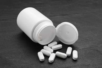 Photo of Antidepressants and medical jar on black background