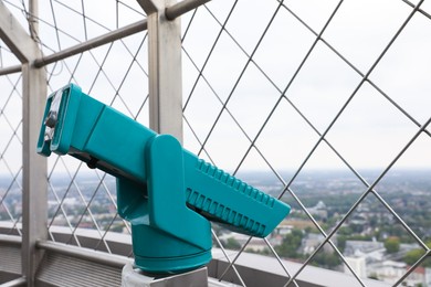 Green metal tower viewer on observation deck. Space for text