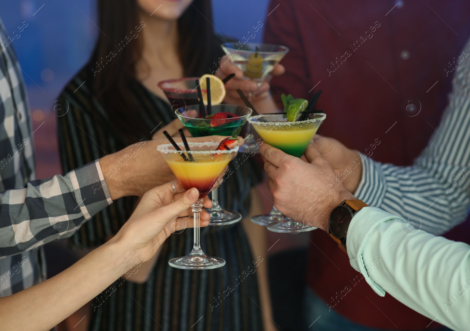 Photo of Group of young people holding martini cocktails at party, closeup