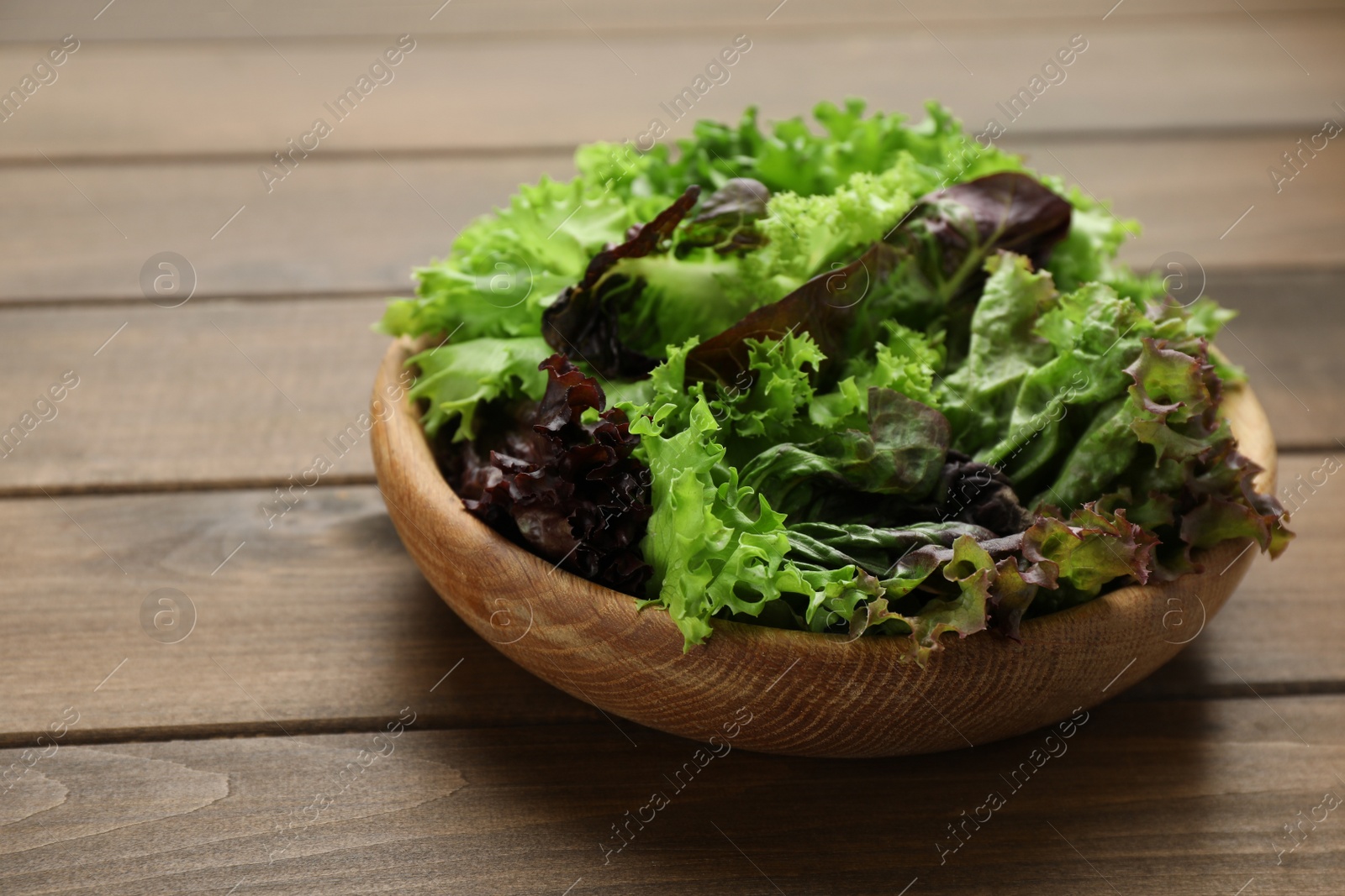 Photo of Different sorts of lettuce on wooden table