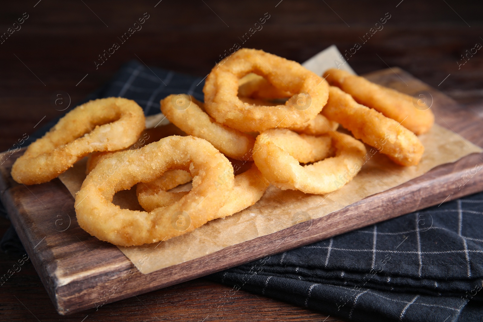 Photo of Fried onion rings served on wooden table