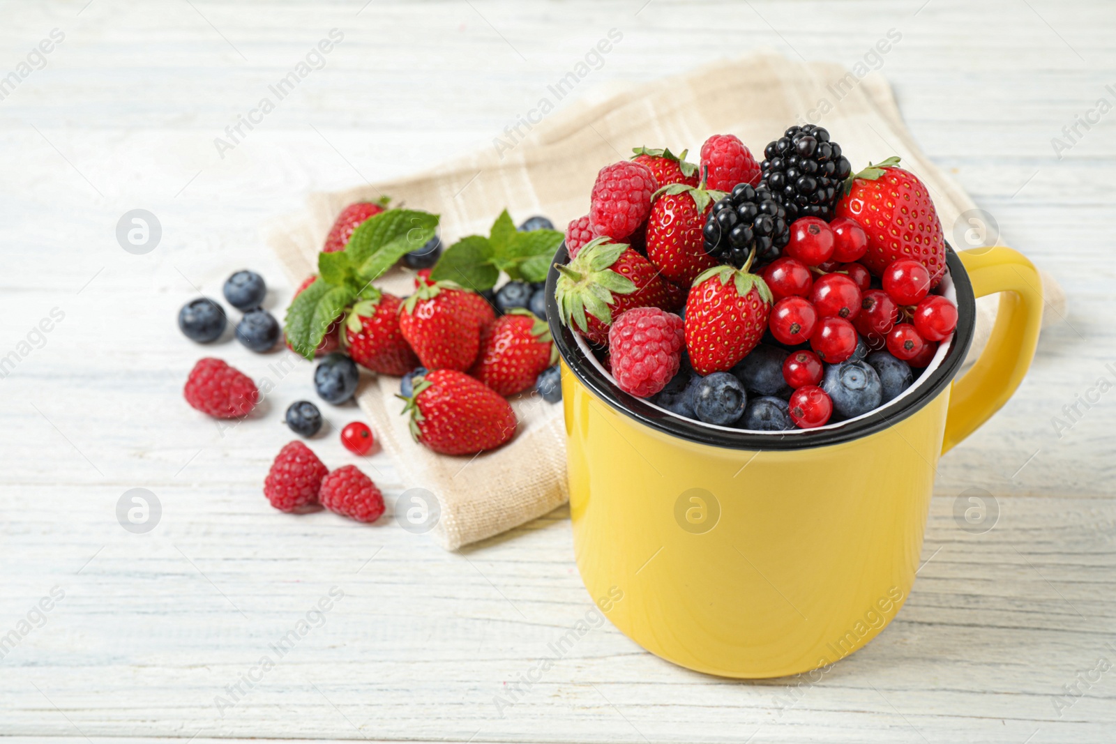 Photo of Mix of ripe berries on white wooden table