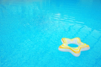 Photo of Inflatable colorful ring floating on water in swimming pool