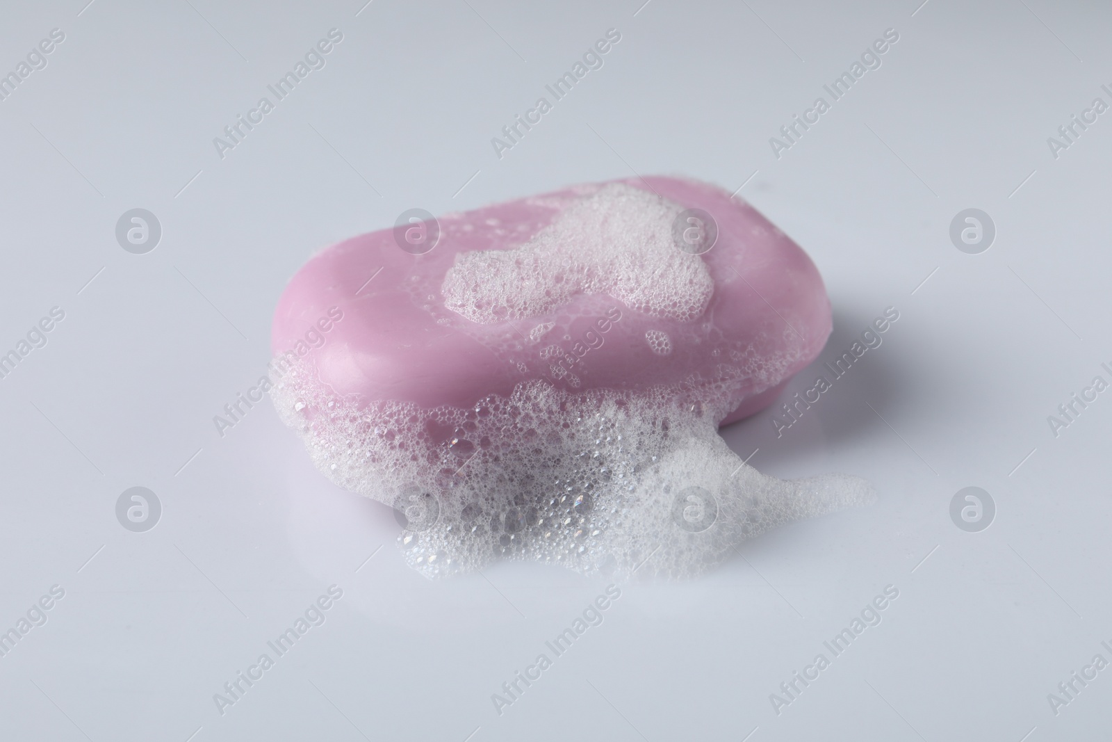 Photo of Soap with fluffy foam on white background