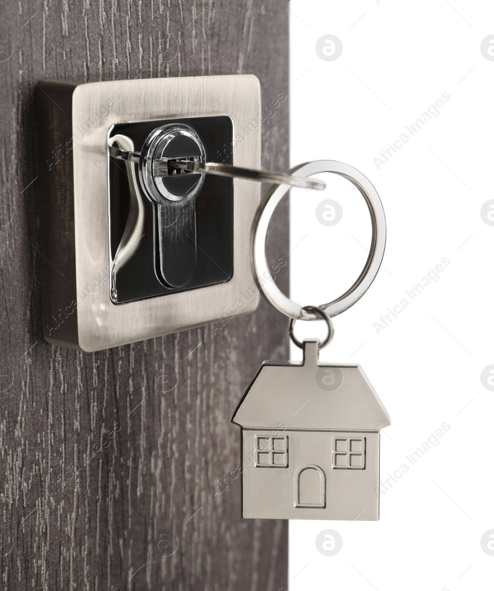 Photo of Mortgage and real estate. Open door with key and house shaped keychain on white background, space for text