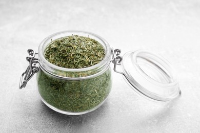 Photo of Jar with dried thyme on grey table, closeup