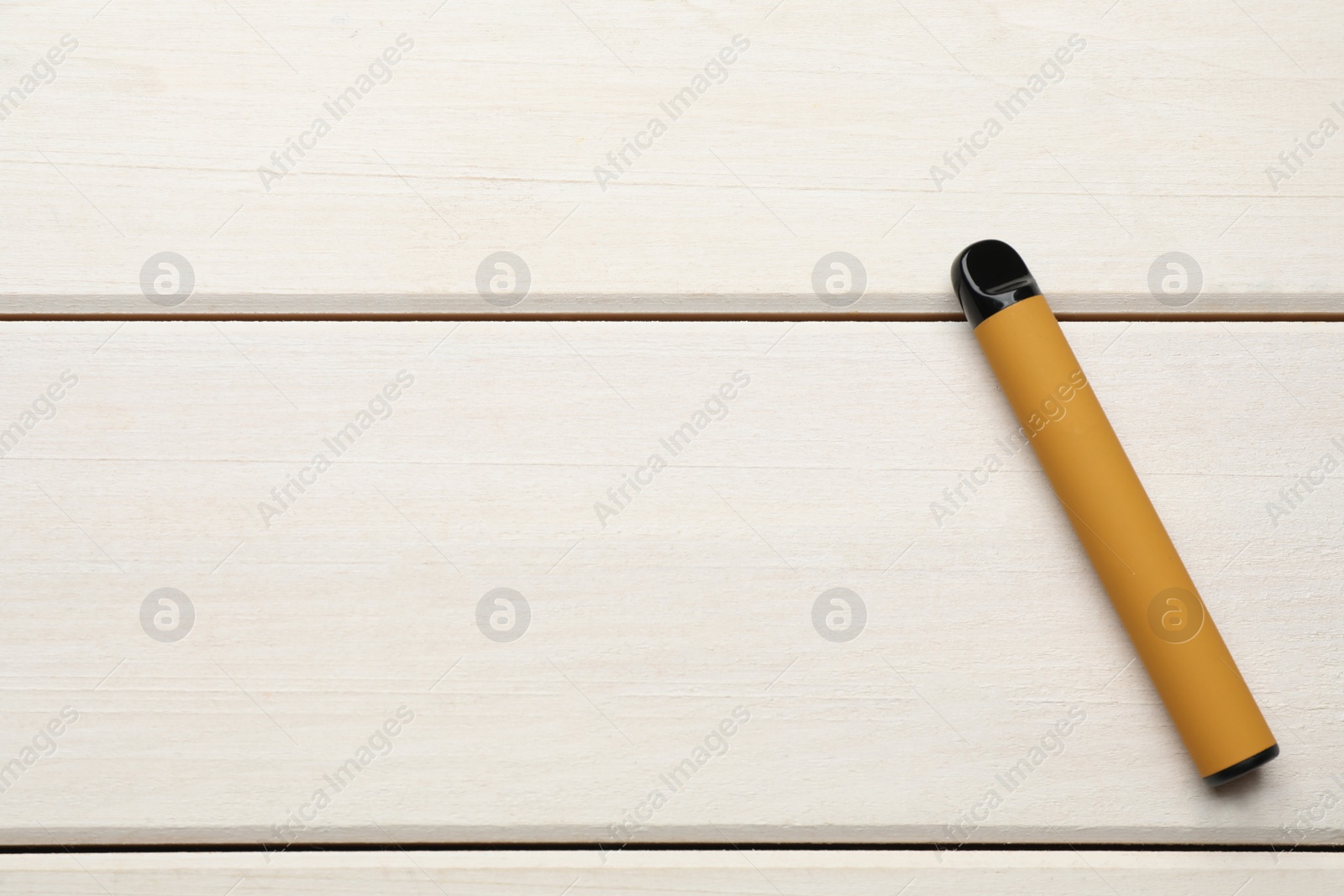 Photo of Disposable electronic cigarette on white wooden table, top view with space for text. Smoking alternative