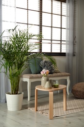 Modern room interior with soft bench and table near window