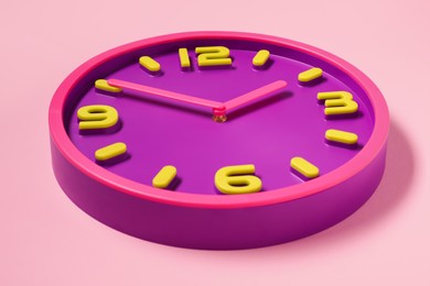 Photo of Stylish round clock on pale pink background. Interior element