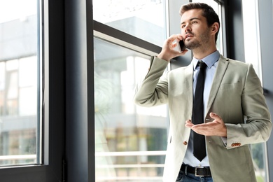 Male business trainer talking on phone in office