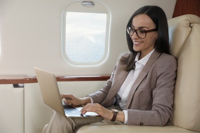 Photo of Businesswoman working on laptop in airplane during flight