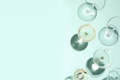 Photo of Set of empty glasses on light blue background, flat lay. Space for text