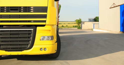 Photo of Modern yellow truck on road, closeup. Space for text