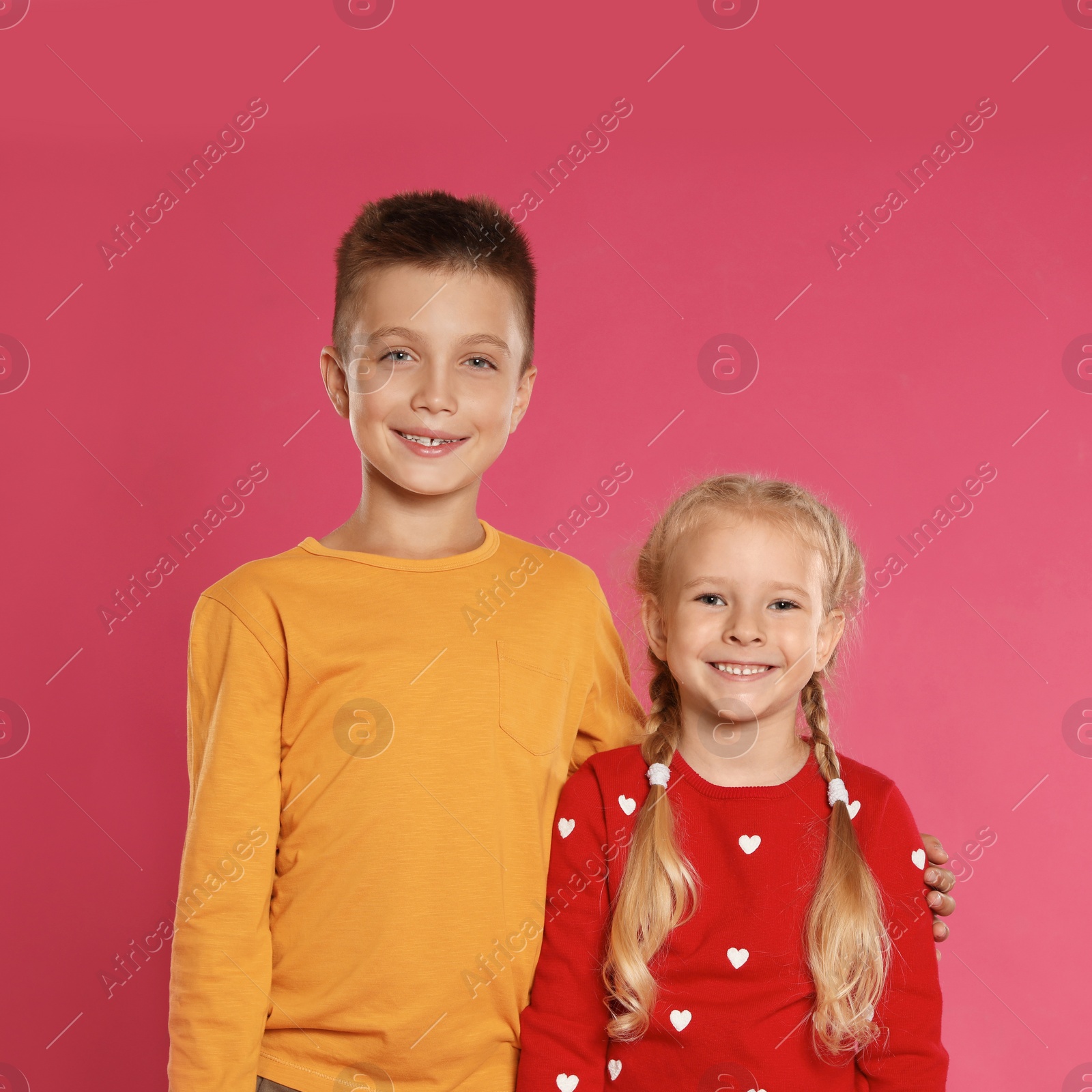 Photo of Cute little children in warm clothes on pink background. Winter season