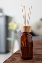 Aromatic reed air freshener on wooden table in room