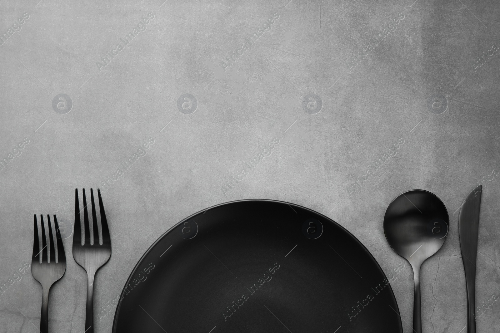 Photo of Clean plate and cutlery on grey table, flat lay. Space for text
