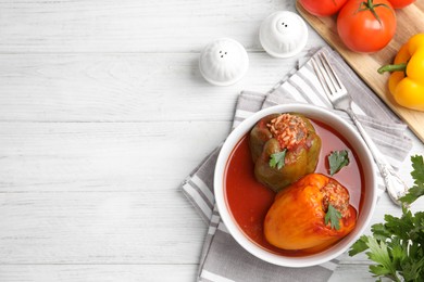 Photo of Delicious stuffed peppers served on white wooden table, flat lay. Space for text